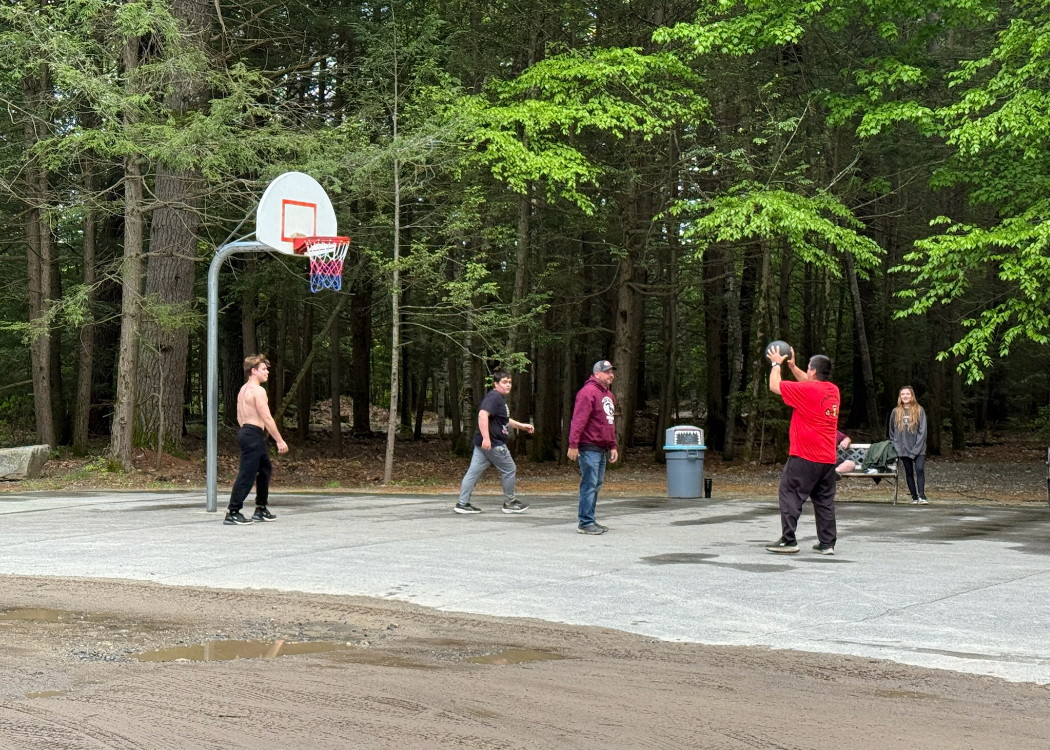 Pleople playing basketball on a court.